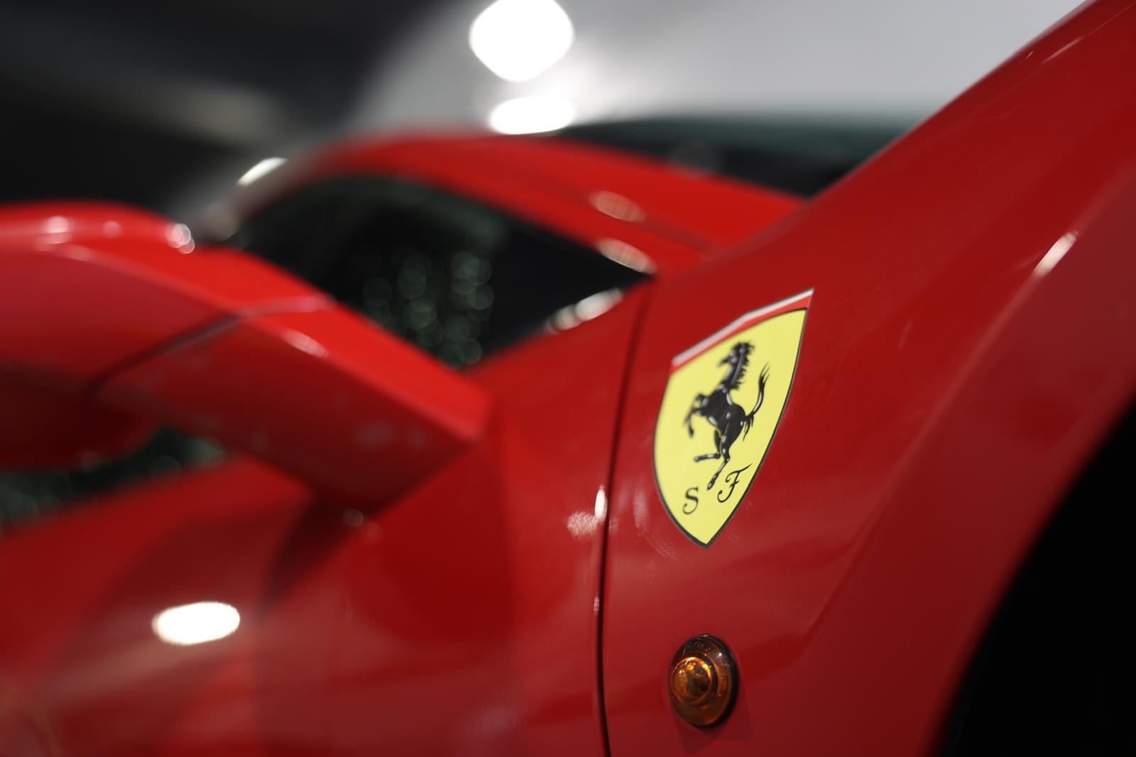 Emblema Ferrari pe caroseria roșie, fotografiată în atelierul SOY TAPI
