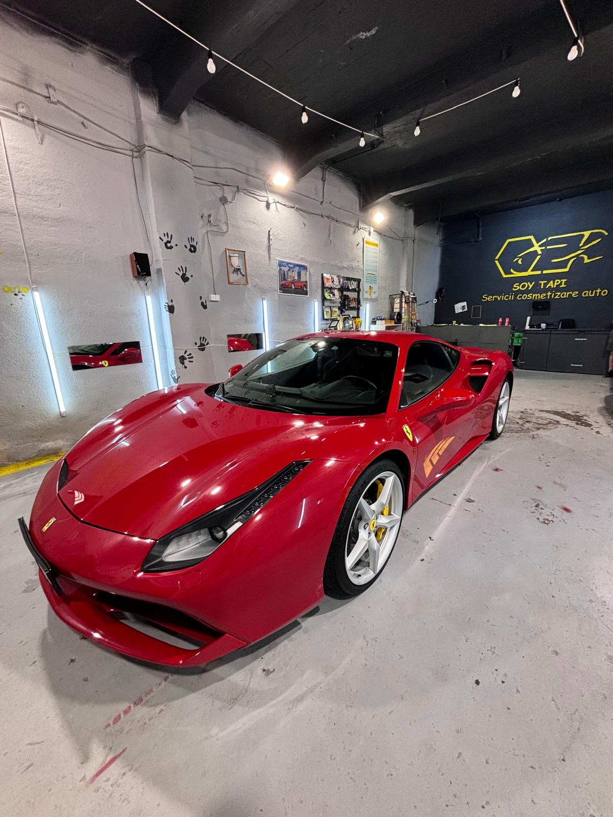 Ferrari roșu fotografiat din față și lateral în atelierul SOY TAPI